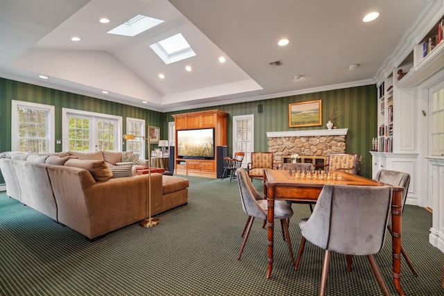 carpeted dining area featuring a fireplace, recessed lighting, visible vents, lofted ceiling with skylight, and wallpapered walls