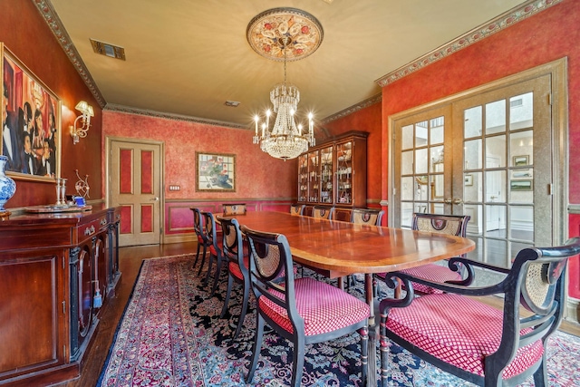 dining area featuring wood finished floors, visible vents, ornamental molding, french doors, and wallpapered walls