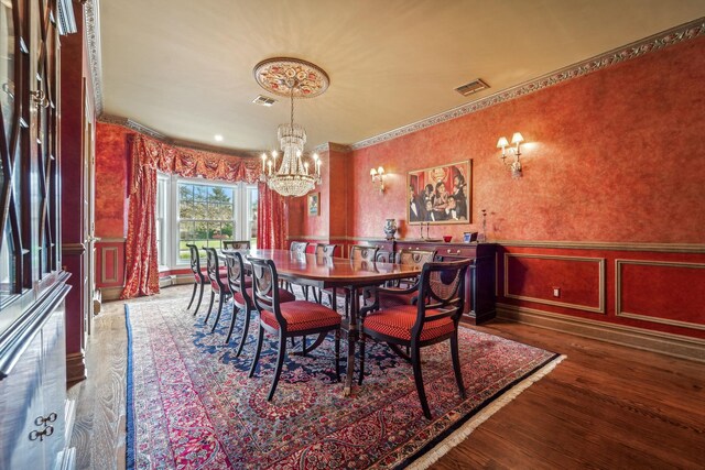 dining room with wallpapered walls, a decorative wall, and wood finished floors