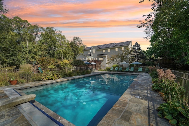 view of pool with a patio area, a playground, fence, and a fenced in pool