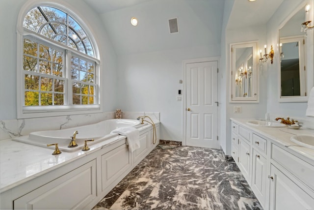 full bath featuring marble finish floor, double vanity, lofted ceiling, a sink, and a bath