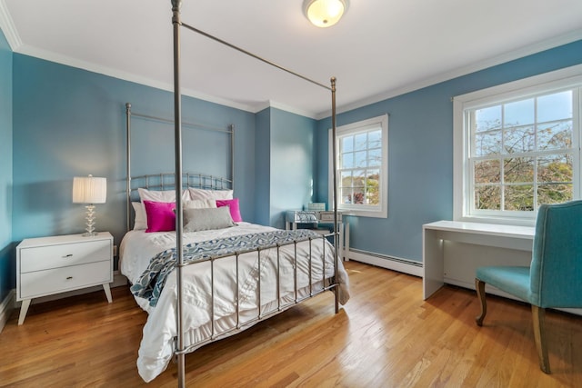 bedroom featuring a baseboard radiator, crown molding, and wood finished floors