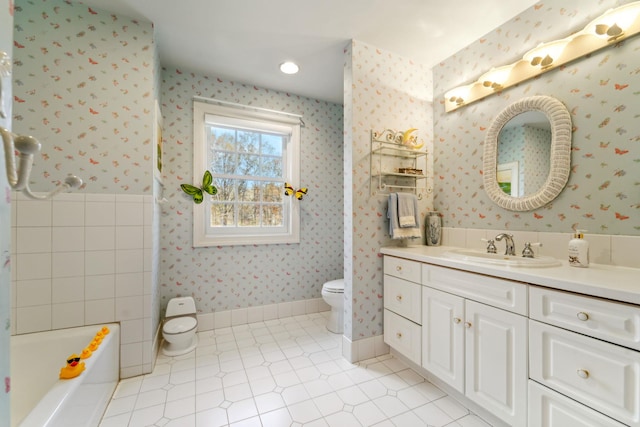 bathroom with vanity, toilet, and wallpapered walls