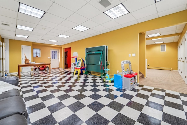 playroom featuring baseboards, visible vents, a baseboard heating unit, and a drop ceiling