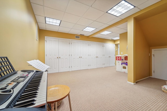 recreation room with carpet floors, visible vents, and a drop ceiling