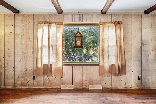 room details featuring wood walls, wood-type flooring, and beam ceiling