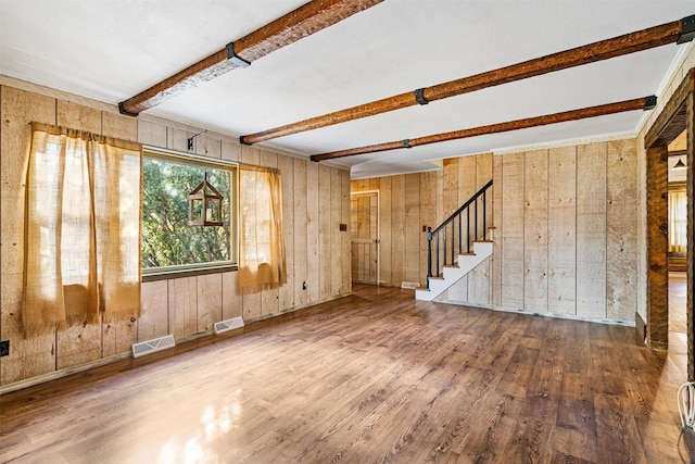 interior space featuring beamed ceiling, hardwood / wood-style floors, and wood walls