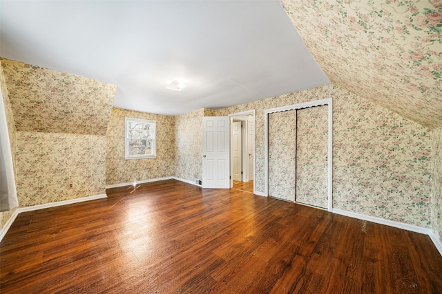 bonus room with dark hardwood / wood-style flooring and vaulted ceiling