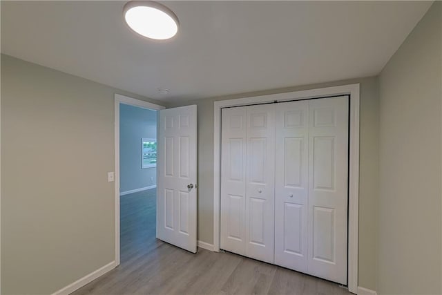 unfurnished bedroom featuring light wood-type flooring and a closet