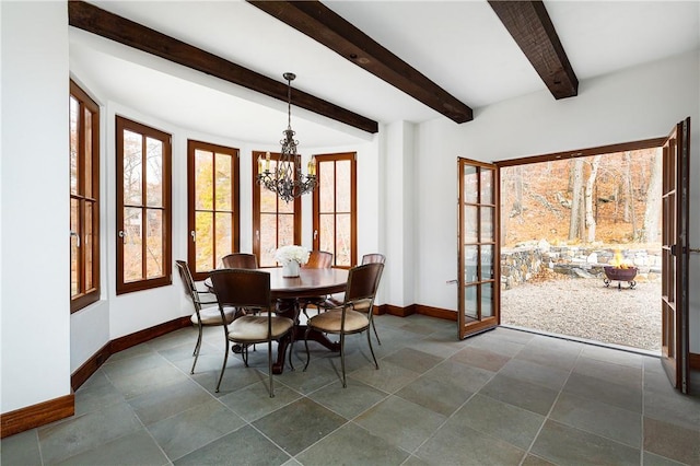 dining space with beamed ceiling, a healthy amount of sunlight, and a notable chandelier