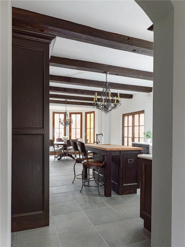 dining area featuring beam ceiling and a notable chandelier