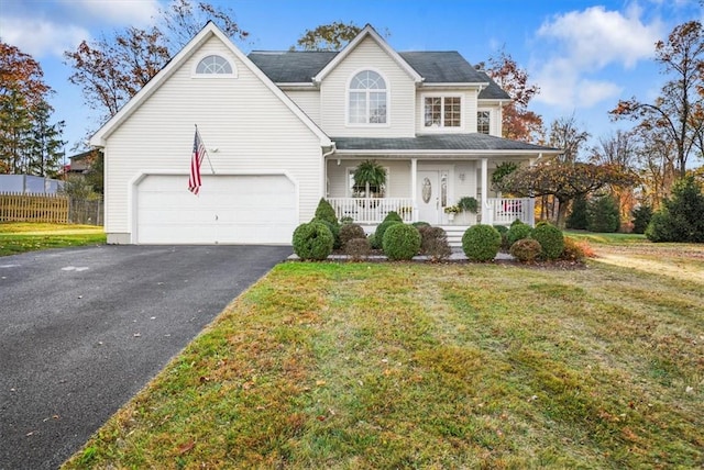 view of front of home with a front lawn, covered porch, and a garage