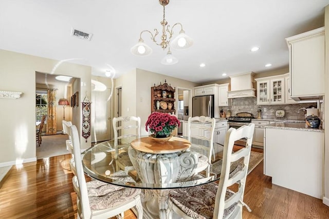 dining space featuring sink, dark wood-type flooring, and a chandelier