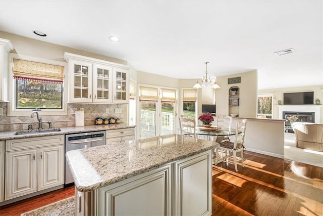 kitchen featuring pendant lighting, a healthy amount of sunlight, sink, and dark wood-type flooring