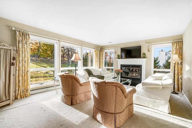 living room with a wealth of natural light, light colored carpet, and a baseboard heating unit