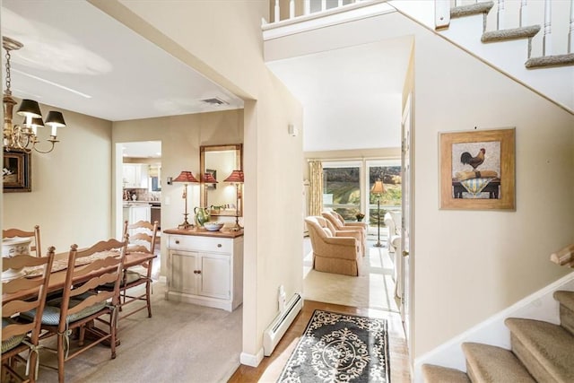 interior space featuring a high ceiling, a baseboard heating unit, and a notable chandelier