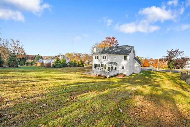 back of property with a lawn and a deck