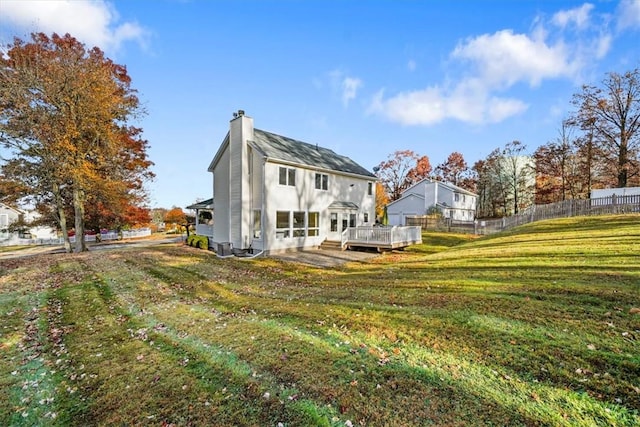 back of property with a lawn and a wooden deck