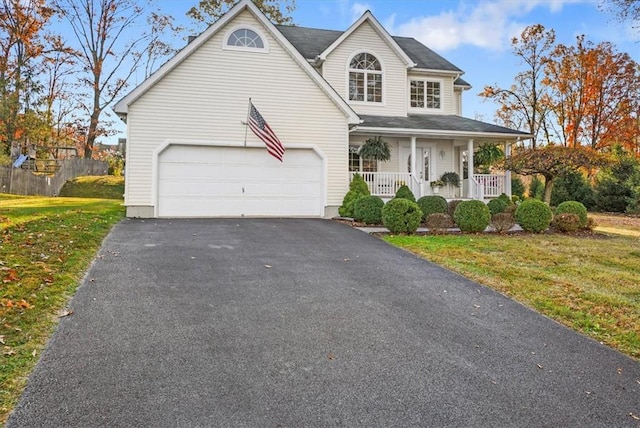 view of front of home with a porch, a garage, and a front yard