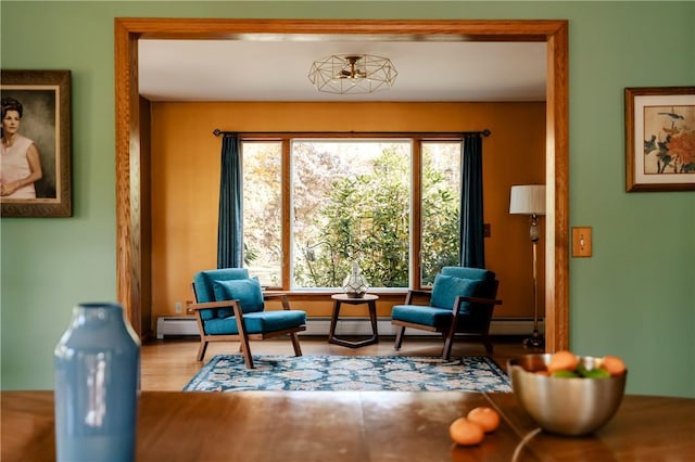 living area featuring hardwood / wood-style floors, a baseboard radiator, and plenty of natural light