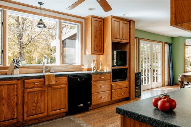 kitchen with french doors, sink, light hardwood / wood-style flooring, black dishwasher, and hanging light fixtures