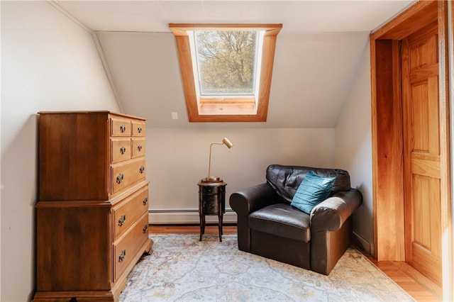 sitting room featuring vaulted ceiling with skylight, a baseboard radiator, and light hardwood / wood-style flooring