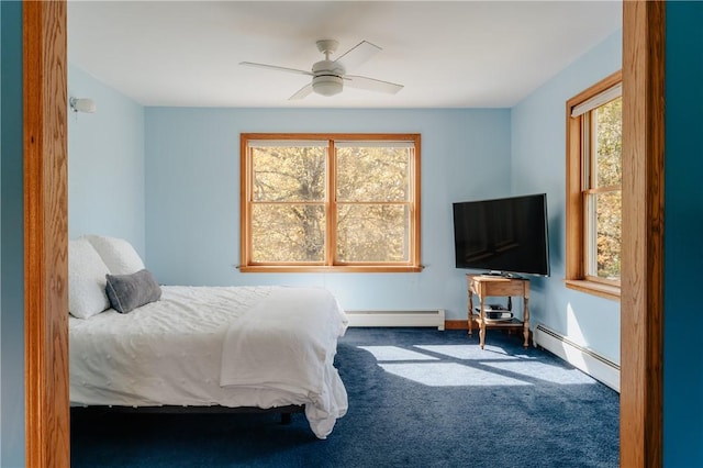 carpeted bedroom with multiple windows, ceiling fan, and a baseboard radiator