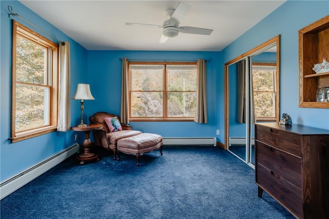 sitting room featuring a wealth of natural light, ceiling fan, and a baseboard heating unit