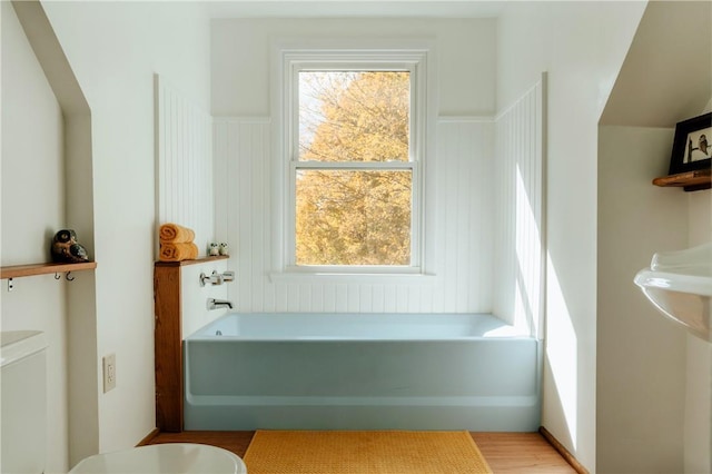 bathroom featuring a tub to relax in and wood-type flooring