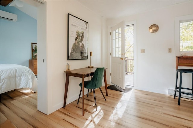 entryway featuring a wall mounted AC, a wealth of natural light, light hardwood / wood-style flooring, and lofted ceiling