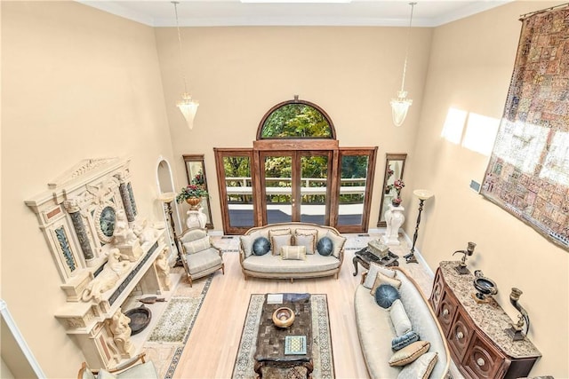 living room with crown molding, hardwood / wood-style floors, and a high ceiling