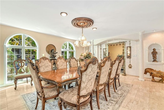 dining room featuring decorative columns and a chandelier