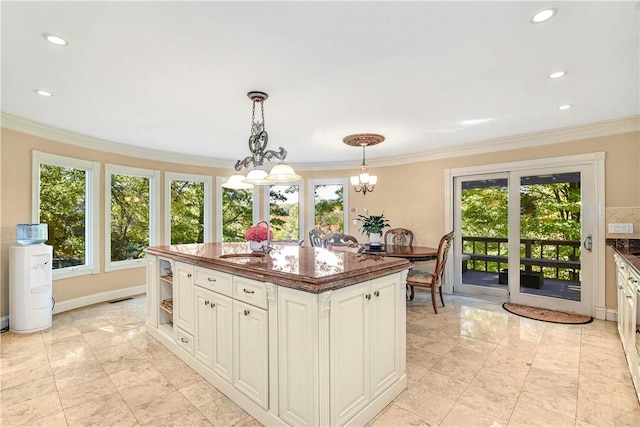 kitchen featuring a chandelier, a center island with sink, a healthy amount of sunlight, and sink