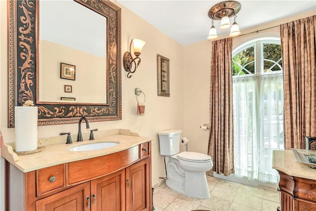 bathroom featuring tile patterned flooring, vanity, and toilet