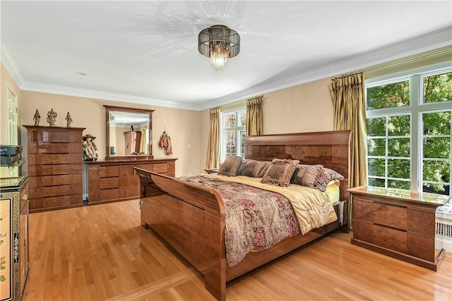 bedroom featuring light hardwood / wood-style flooring and crown molding