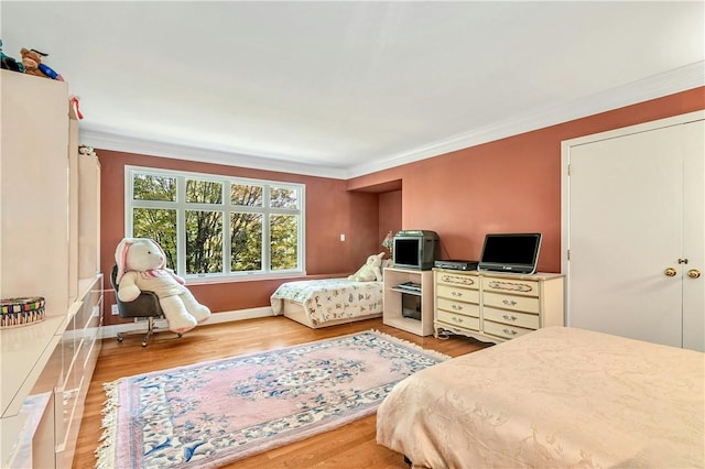 bedroom with light wood-type flooring and ornamental molding