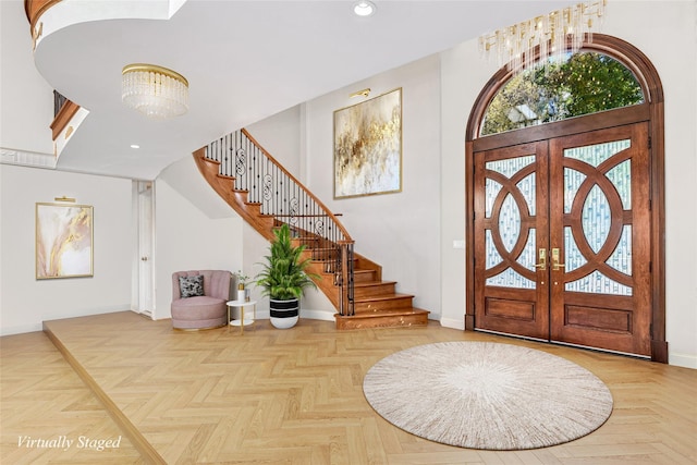 entryway with a chandelier, parquet floors, and french doors