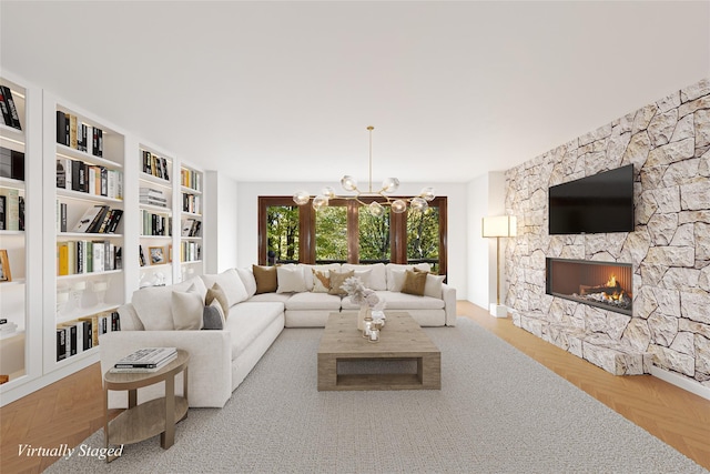 living room with a stone fireplace and an inviting chandelier