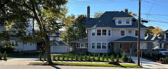 view of front of home featuring an outbuilding, a garage, and a front lawn