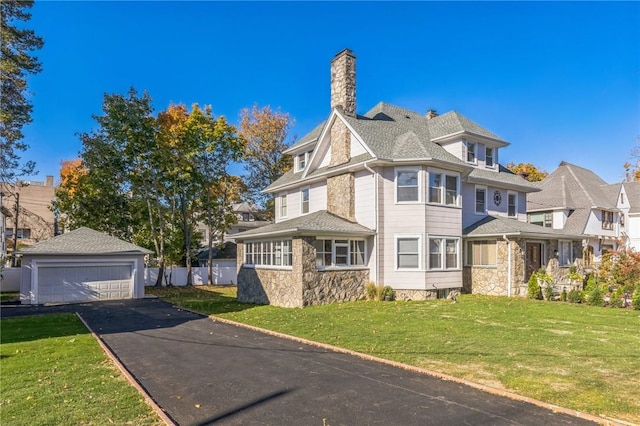 victorian house with a garage, an outdoor structure, and a front lawn