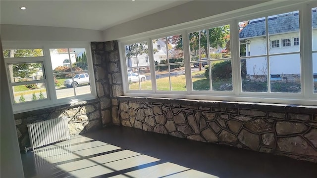 unfurnished sunroom featuring a healthy amount of sunlight and radiator heating unit