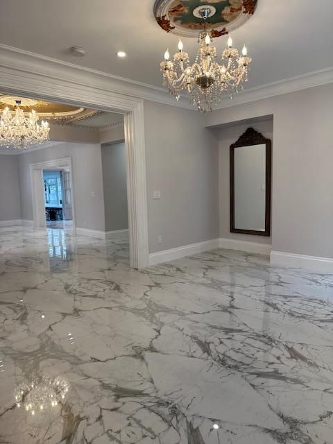 unfurnished room featuring ornamental molding and a notable chandelier