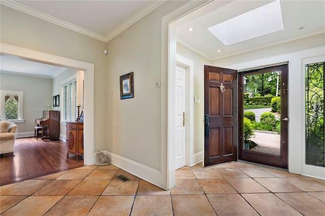 entrance foyer with light hardwood / wood-style floors, ornamental molding, a wealth of natural light, and a skylight