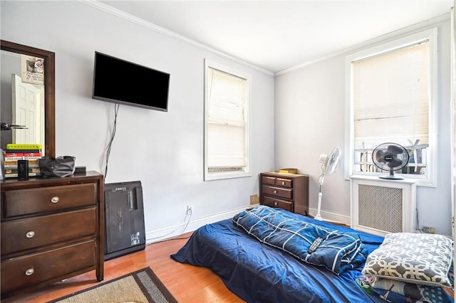 bedroom with ornamental molding and light hardwood / wood-style flooring