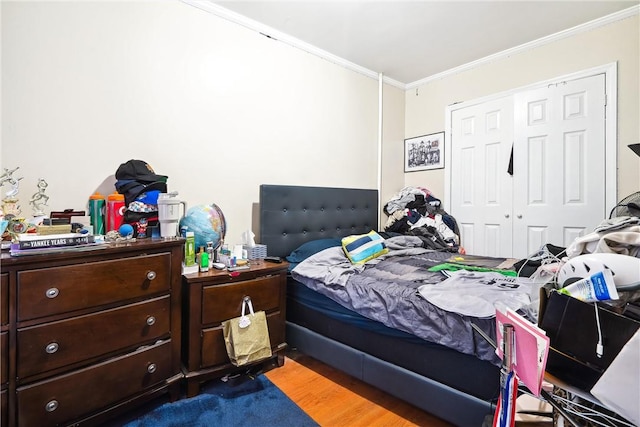 bedroom with a closet, ornamental molding, and hardwood / wood-style flooring