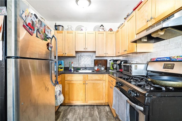 kitchen featuring appliances with stainless steel finishes, light brown cabinetry, tasteful backsplash, sink, and dark hardwood / wood-style floors