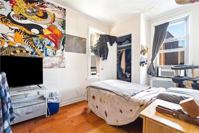 bedroom featuring hardwood / wood-style floors, a closet, and ornamental molding