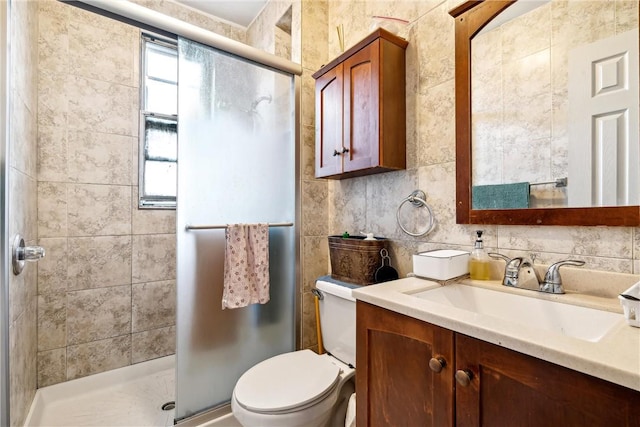 bathroom featuring vanity, a shower with shower door, tile walls, and toilet