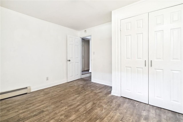 unfurnished bedroom featuring a closet, dark wood-type flooring, and a baseboard radiator