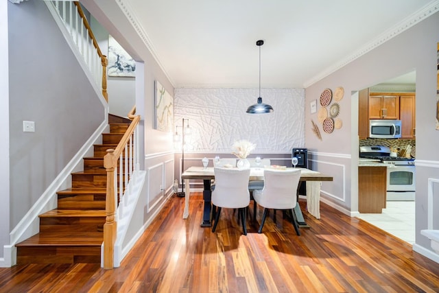 dining area featuring dark hardwood / wood-style flooring and crown molding